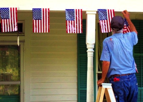 Sanford "Bud" Wiseheart hanging the flags for the 4th of July.